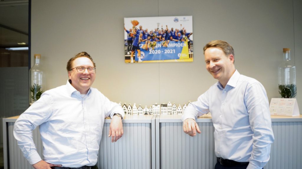 Gerben Janson (links) en Joost van den Berg van Leidse Letselschade Advocaten bij een foto van het kampioensteam in 2021.